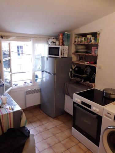 a kitchen with a refrigerator and a microwave at Droite in Nice