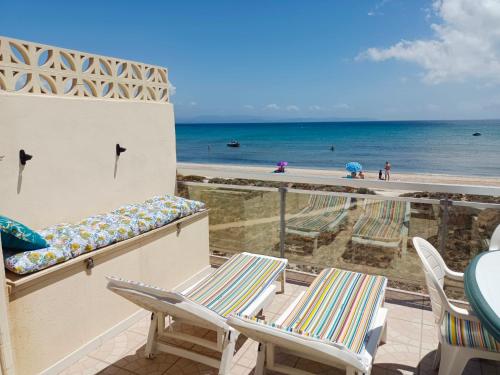 d'un balcon avec des chaises et une vue sur la plage. dans l'établissement Appartement Pieds dans l'Eau, à Hyères