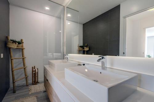 ein weißes Badezimmer mit einem Waschbecken und einem Spiegel in der Unterkunft Hillside house- Modern, upscale home w/SEA VIEWS in Estepona