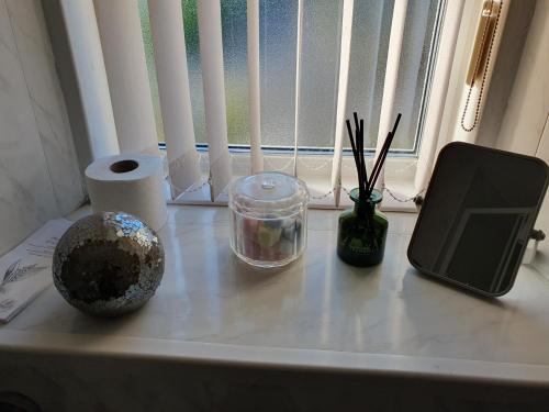 a table with a tablet and other items on a window sill at Kirkcroft Guest House in Gretna