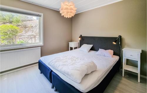 1 dormitorio con cama, ventana y lámpara de araña en 2 Bedroom Amazing Home In Brastad, en Brastad