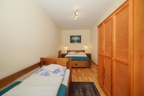 a bedroom with two beds and a closet at APARTAMENTY i POKOJE "PASJA" - 2 minuty do plaży in Dźwirzyno