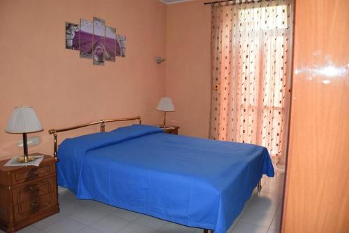 Un dormitorio con una cama azul y una ventana. en Appartamento Torino-zona Politecnico, en Turín