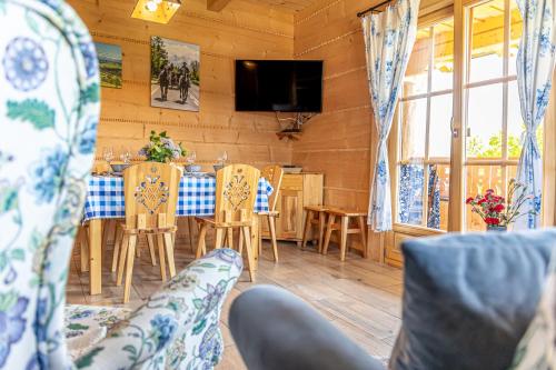 - une salle à manger avec une table, des chaises et une télévision dans l'établissement Domki Sarnówka, à Czarna Góra
