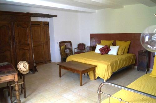 ein Schlafzimmer mit einem Bett und einem Tisch darin in der Unterkunft Chambre d'Hôte dans MAS proche Anduze Cévennes avec piscine in Mialet