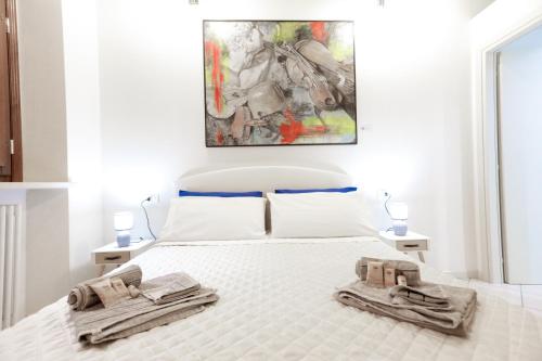 una camera da letto con un letto bianco con due asciugamani di Appartamento Andrea Amati nel Cuore di Cremona a Cremona