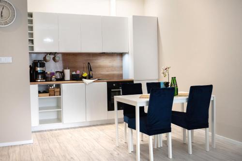 a kitchen with a table and chairs in a room at Blue Sea Apartment & SPA 8/2 in Dziwnów