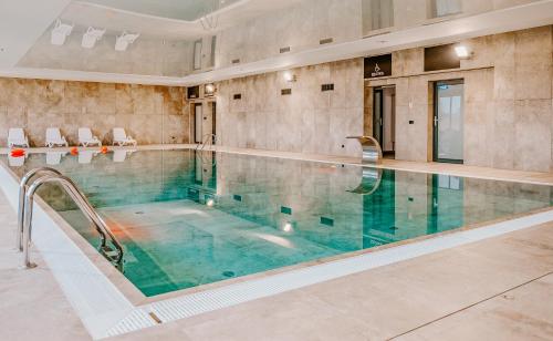 a large swimming pool in a large room with a pool at Blue Sea Apartment & SPA 8/2 in Dziwnów