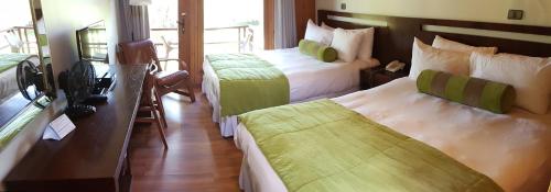 ロス・アンヘレスにあるHotel y Cabañas Las Mellizas - Caja Los Andesのベッド2台と窓が備わるホテルルームです。