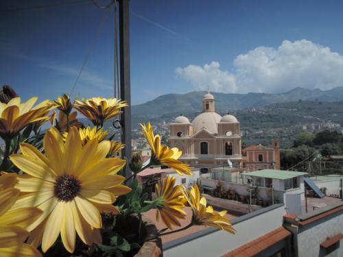 a view of a church from a balcony with flowers at La Casa nel Cortile in Vico Equense