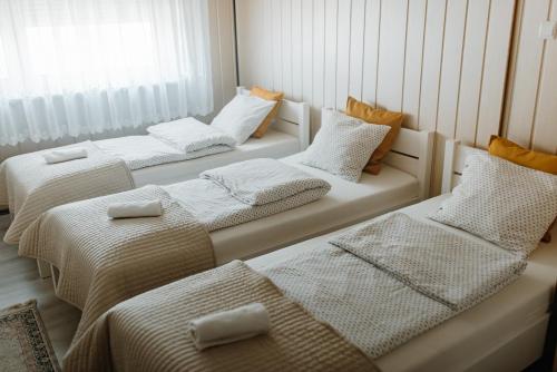 eine Gruppe von 3 Betten in einem Zimmer in der Unterkunft Apartament Jutrzenka in Spytkowice