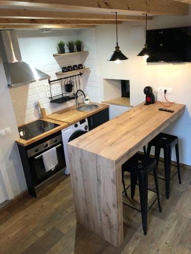 a kitchen with a wooden island in the middle at Apartamentos El Arroyo in Armal