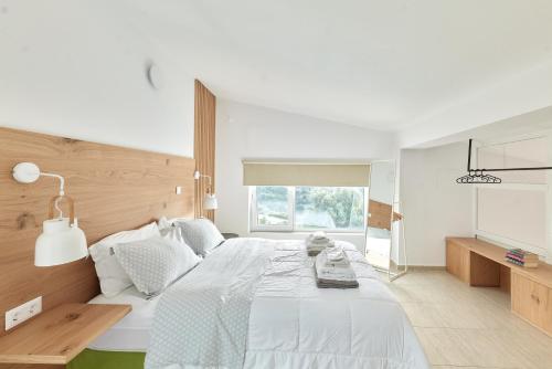 Agia TriadaにあるMoly - Luxury Villa with Heated Private Poolの白いベッドルーム(大型ベッド1台、窓付)