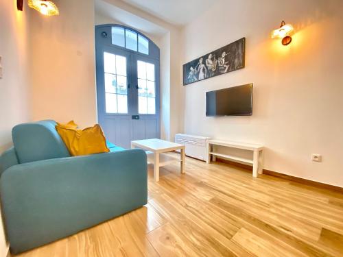 un salon avec un canapé bleu et une télévision dans l'établissement Le Perrissol By SCLS Locations, à Cannes