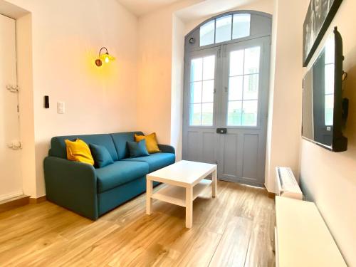 un salon avec un canapé bleu et une table dans l'établissement Le Perrissol By SCLS Locations, à Cannes