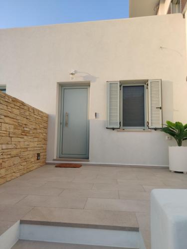 a room with white walls and a door and a plant at Lipsi Sands in Lipsoi