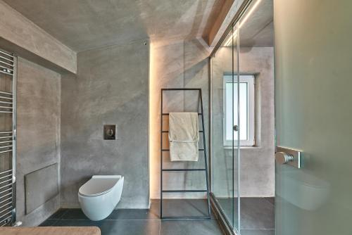 a bathroom with a toilet and a glass shower at Moly - Luxury Villa with Heated Private Pool in Agia Triada
