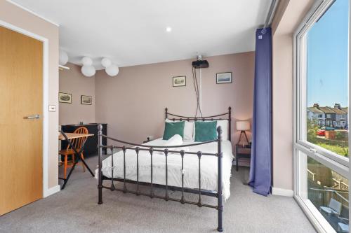 a bedroom with a bed and a window at Modern House with Parking Buisness and Leisure in Brighton & Hove