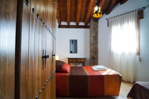 Schlafzimmer mit einem Bett und einer Holztür in der Unterkunft Casa Rural Cortijo el Plantío in Castril