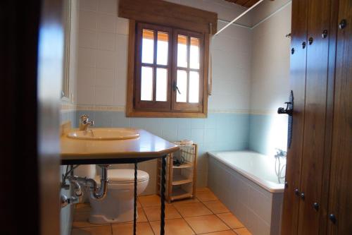 y baño con lavabo, aseo y bañera. en Casa Rural Cortijo el Plantío, en Castril
