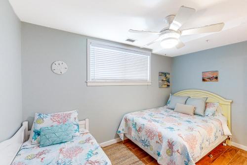 a bedroom with a bed and a clock on the wall at The Sanctuary - Summer Breeze A114 in Virginia Beach