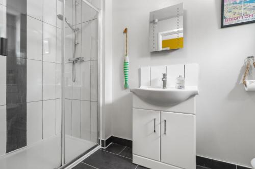 a white bathroom with a sink and a shower at Modern House with Parking Buisness and Leisure in Brighton & Hove