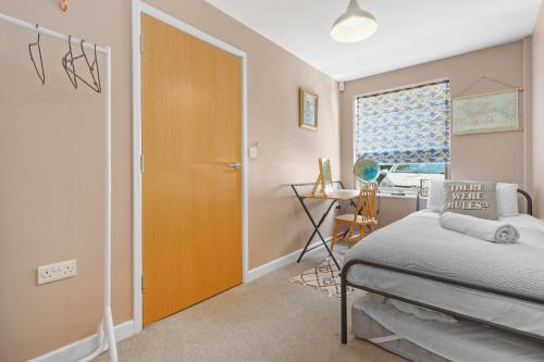 a bedroom with a bed and a desk and a window at Modern House with Parking Buisness and Leisure in Brighton & Hove