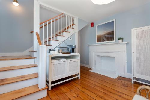 a living room with stairs and a fireplace at Nantucket Periwinkle in Nantucket