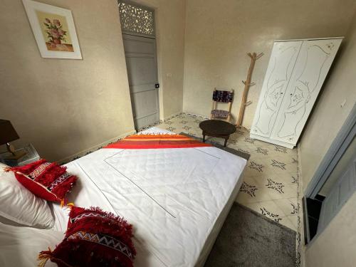 a bedroom with a white bed with red pillows on it at Oasis Merasi Marrakech in Marrakech