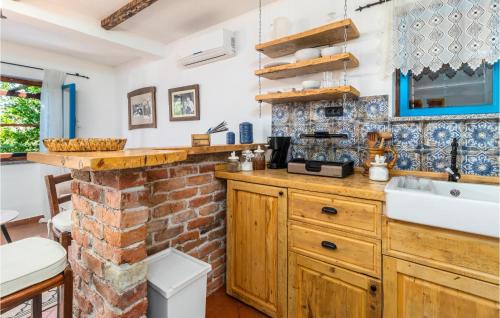cocina con fregadero y pared de ladrillo en Amazing Apartment In Klada With Kitchen, en Klada