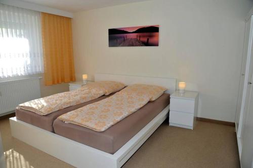 a bedroom with a bed with two nightstands and avertisement at Ferienwohnung Nachtigall in Burg