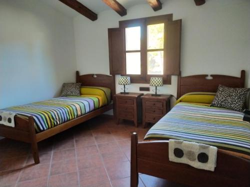 um quarto com 2 camas e uma janela em Can Cruset agroturisme em Torrellas de Foix