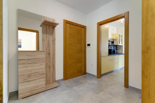 a hallway with two wooden doors and a kitchen at Villa Panorama in Senj