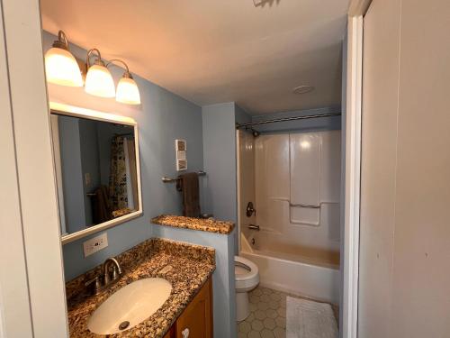 a bathroom with a sink and a toilet and a mirror at Glimpse of Grace at the Bay in Gulf Shores