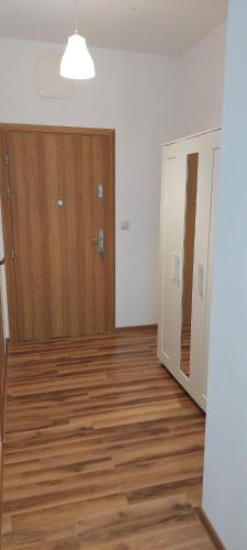 ein leeres Zimmer mit Holzböden und einer Tür in der Unterkunft Apartamenty Niko in Zator