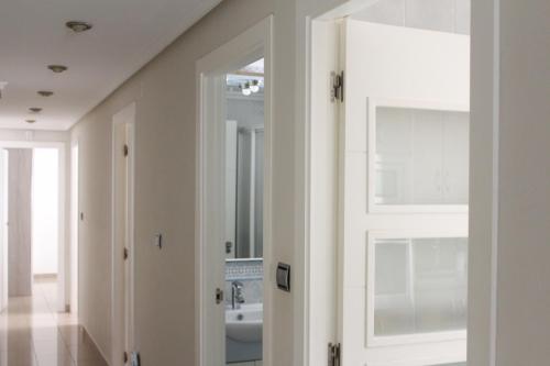 Una puerta blanca en una habitación con baño. en Apartamento Bahía, en Santa Pola
