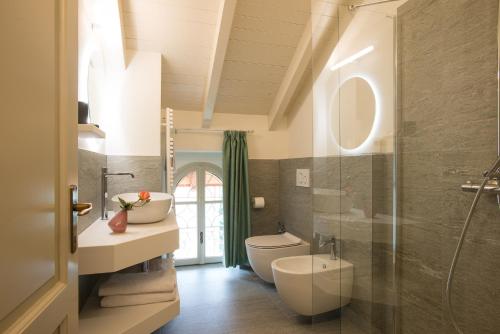 een badkamer met een toilet, een wastafel en een douche bij Residence Ortensia in Baveno