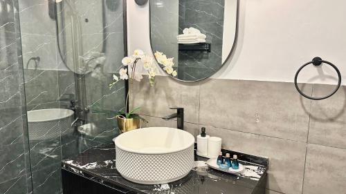 a bathroom with a sink and a mirror at Desert Flower Delight in Al Qurayyah