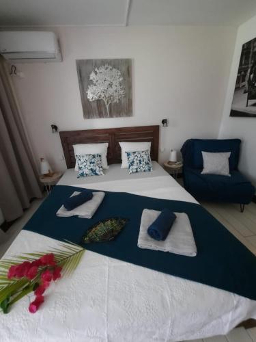 a bedroom with a bed with towels and a chair at Ti'Masani in Saint-François