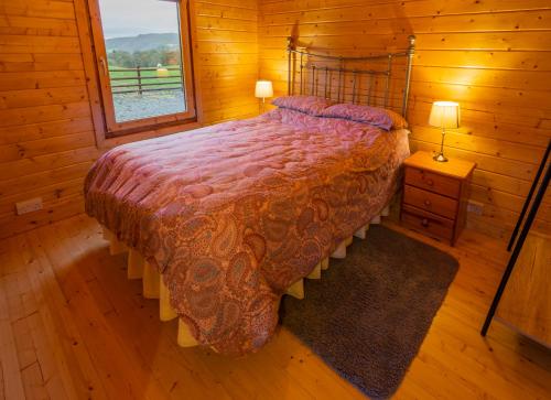 a bedroom with a bed in a wooden cabin at Amazing Views Log Cabin Broughton Mills South Lakes in lower hawthwaite