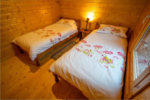 a bedroom with two beds in a wooden cabin at Amazing Views Log Cabin Broughton Mills South Lakes in lower hawthwaite