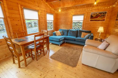 a living room with a couch and a table at Amazing Views Log Cabin Broughton Mills South Lakes in lower hawthwaite