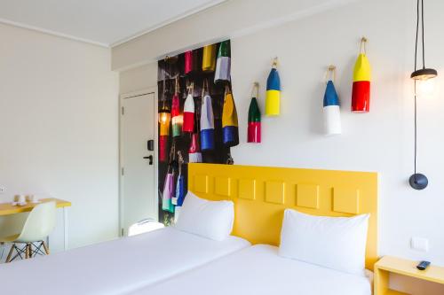 a bedroom with a bed and a wall with colorful umbrellas at Ibis Styles Lisboa Centro Liberdade NE in Lisbon