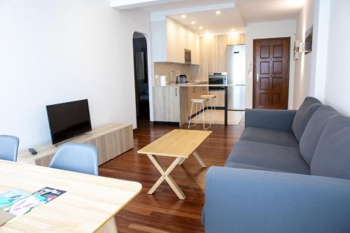 a living room with a couch and a table and a kitchen at Egona- Vivienda en el centro de Zarautz a 1 min de la playa in Zarautz