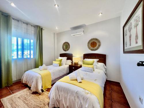 - une chambre avec 2 lits et une fenêtre dans l'établissement Finca La María, à Jaén