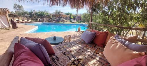 a couch sitting in front of a swimming pool at Les Jardins de Taja in Ourika