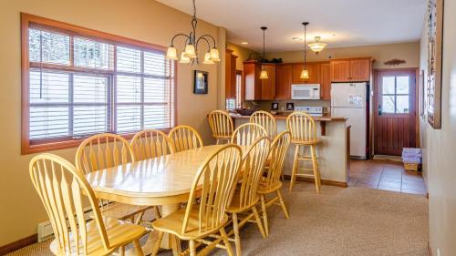 a kitchen and dining room with a wooden table and chairs at Trails Edge #03 By Bear Country in Sun Peaks