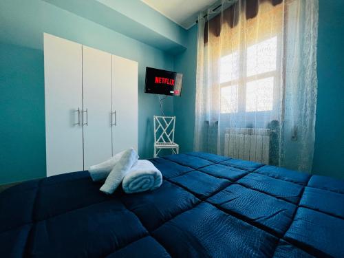 Un dormitorio azul con una cama con toallas. en [Chi Ama il Mare] Appartamento, en Latina