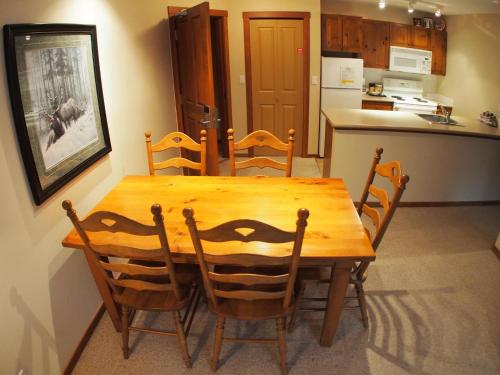 y cocina con mesa de comedor de madera y sillas. en Fireside Lodge #302 By Bear Country, en Sun Peaks