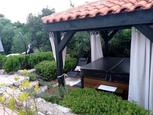a gazebo with a piano in a garden at Lavender Hill Hvar Villa - pool, jacuzzi,sauna,BBQ in Stari Grad